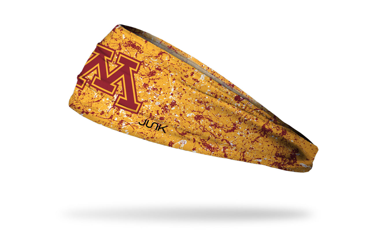gold headband with maroon paint splatter and University of Minnesota M logo in maroon