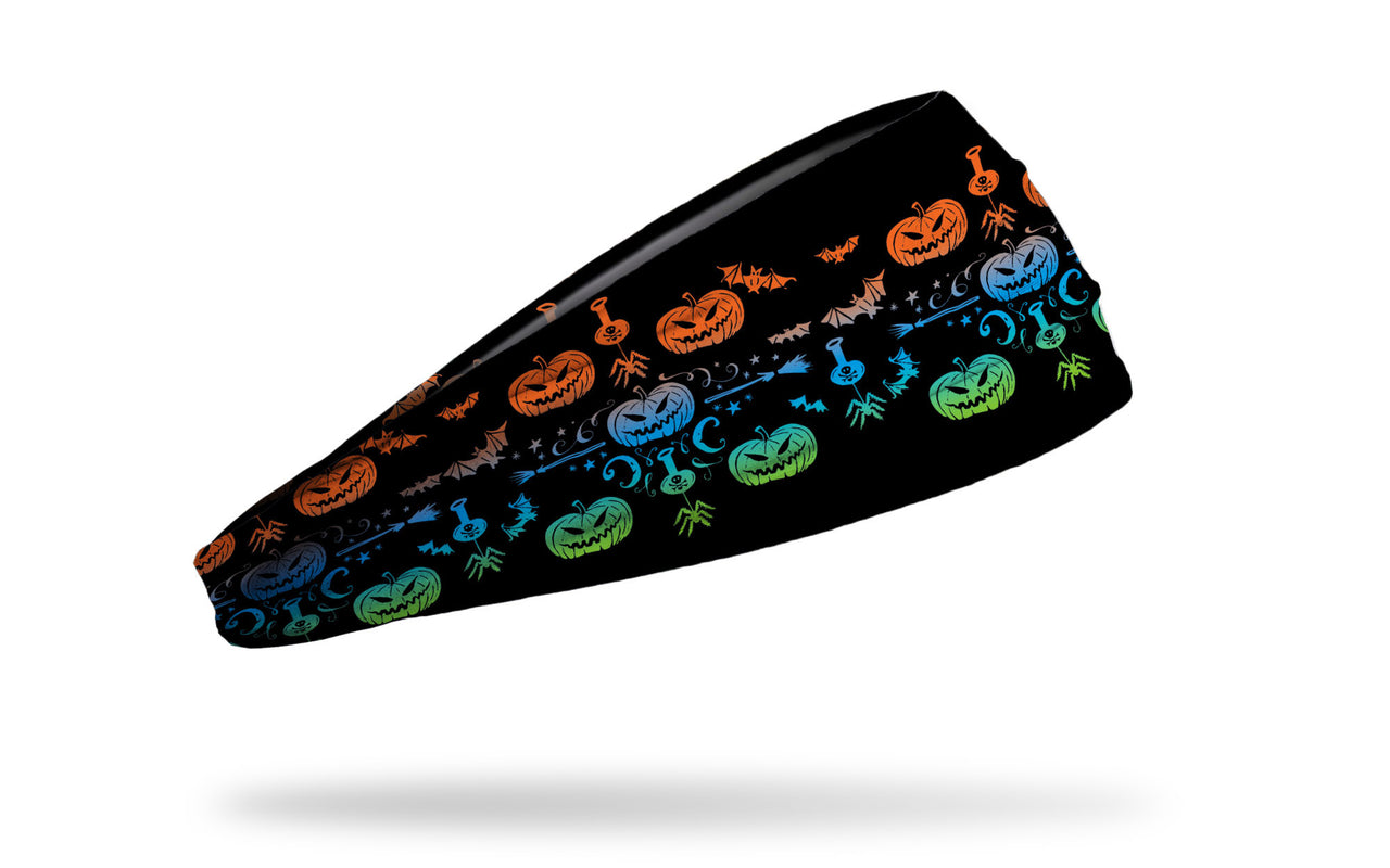 black headband with pattern of jack o lanterns, spiders, brooms, and potions in bright colors